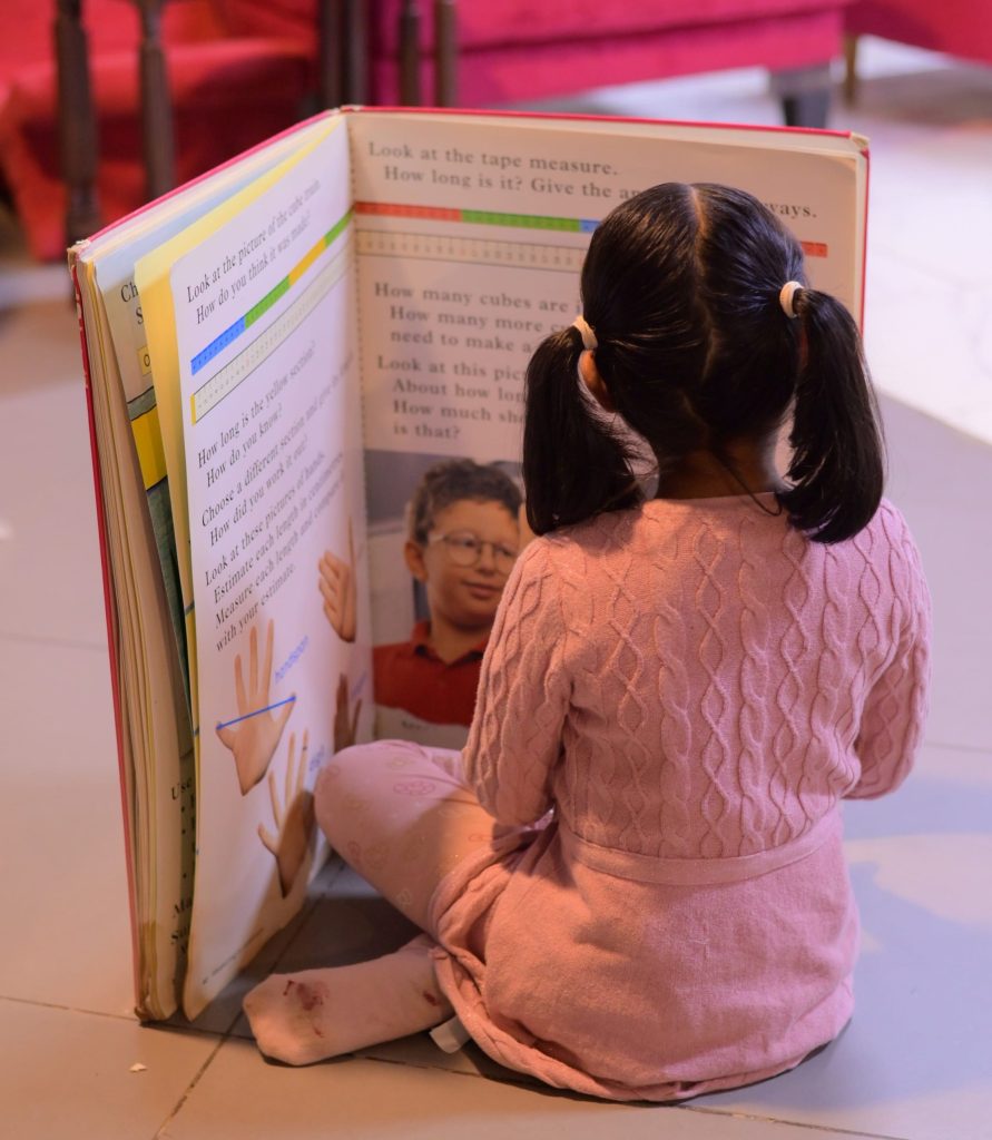 Girl Reading Huge Book No Face Pigtails